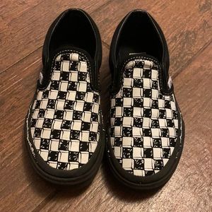 Kids slip on black/white checkered Vans.